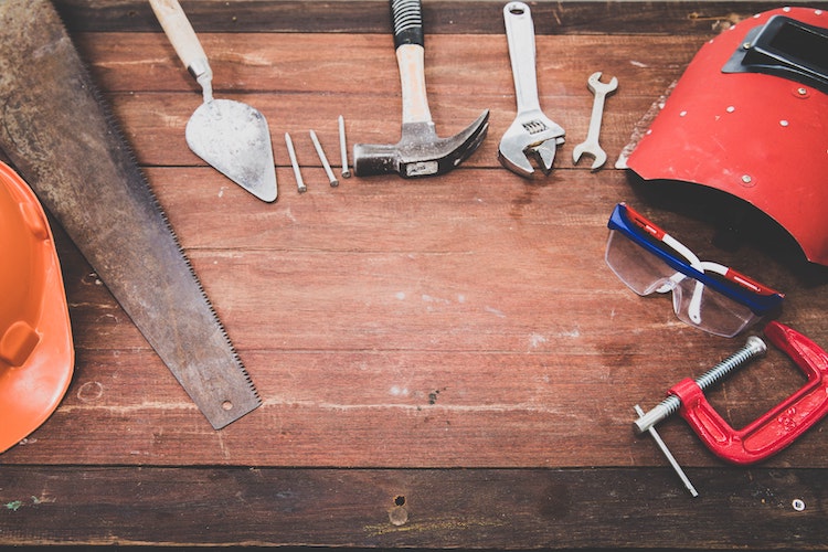 A picture of different types of tools placed on a wooden table